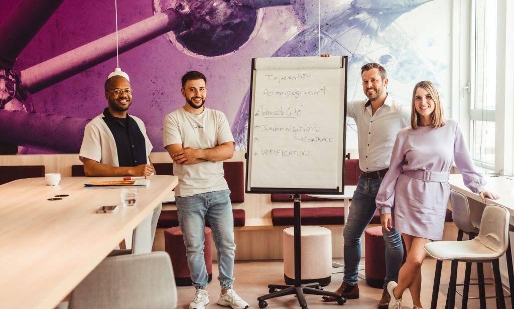 4 personnes posant devant un flip chart